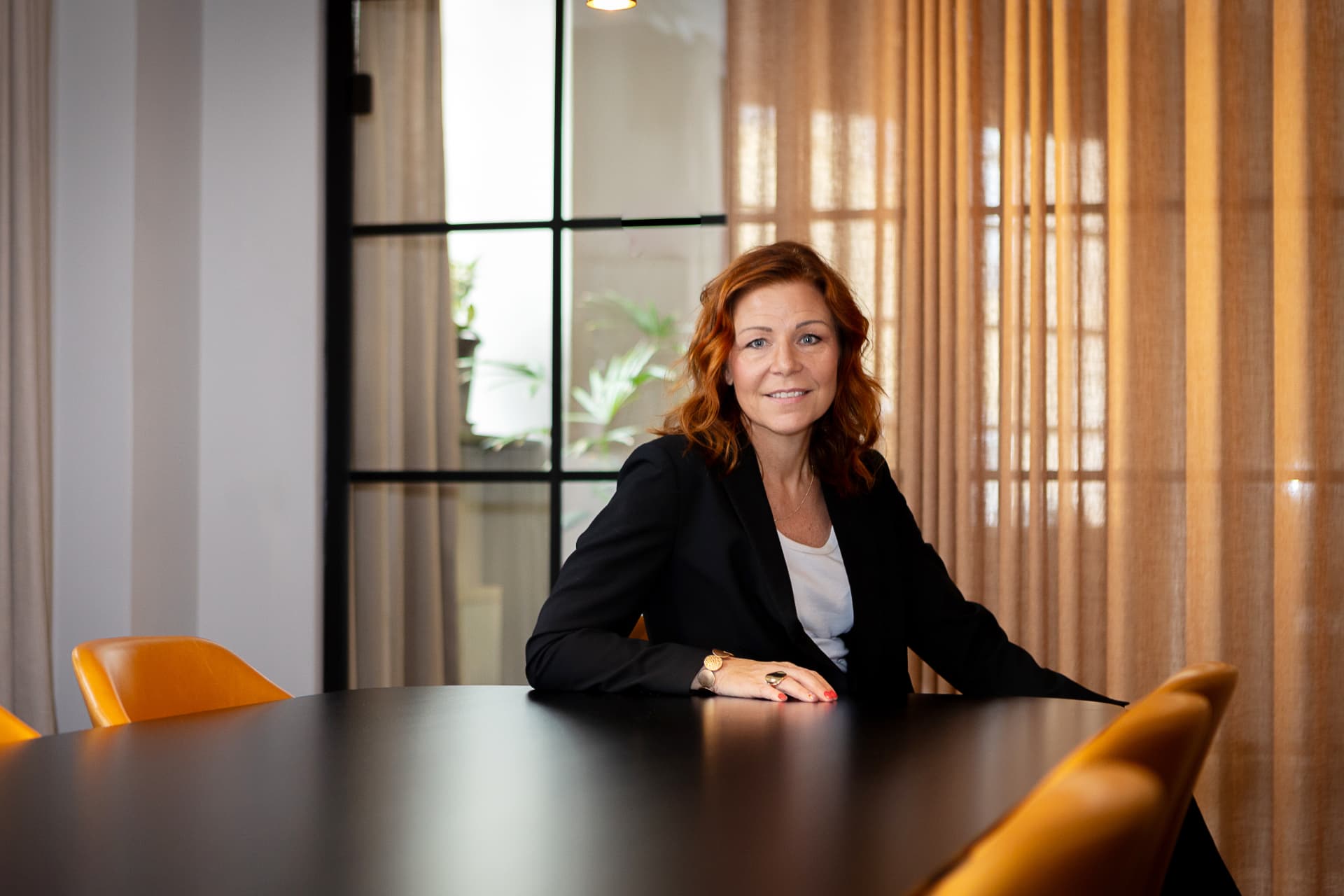 Sandra Sundbäck sitter vid ett mötesbord
